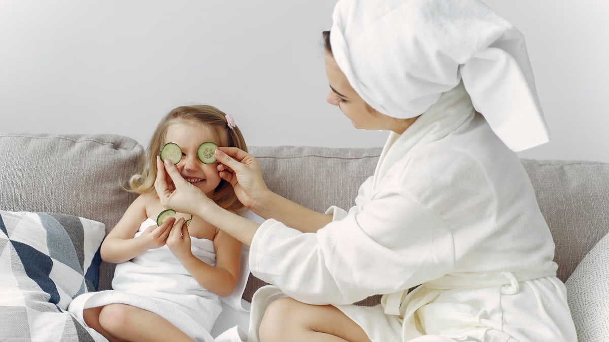 A mother and daughter enjoy a relaxing spa day at home with cucumbers and laughter.
